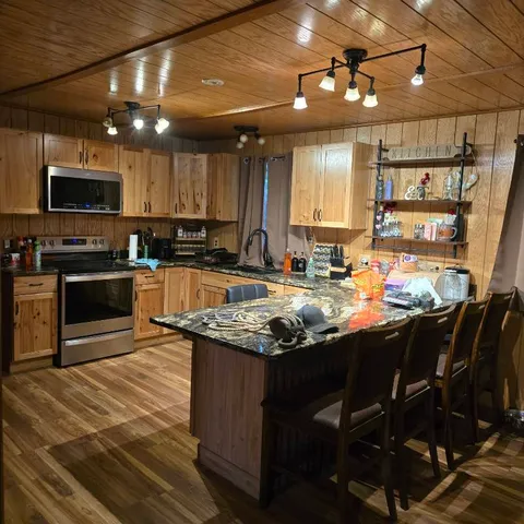 a kitchen with stainless steel appliances granite countertop a stove sink and cabinets