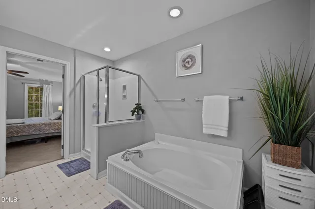 a bathroom with a tub a sink and a shower