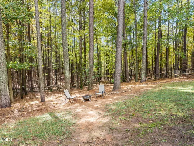 a view of swimming pool with lawn chairs and wooden fence