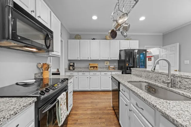 a kitchen with kitchen island granite countertop a sink stainless steel appliances and cabinets