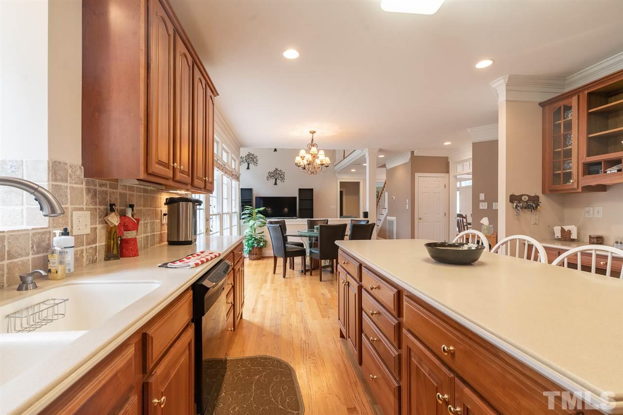 5209 Tallowtree Drive Raleigh, NC 27613 - Photo 8 of 22 a kitchen with a sink a stove and chairs