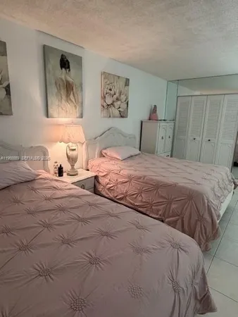 a bedroom with a bed and two painting on the wall