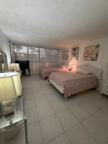 a bedroom with a bed and view of living room