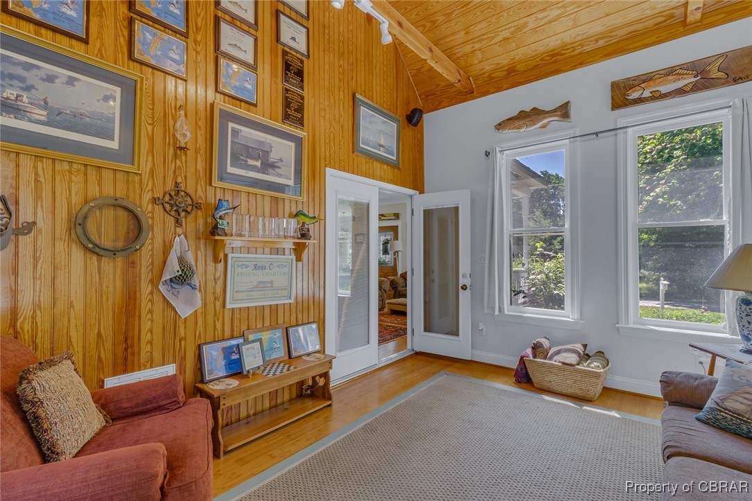 189 Virginia Road Reedville, VA 22539 - Photo 22 of 46 Living room with wooden ceiling, wood walls, wood finished floors, and baseboards