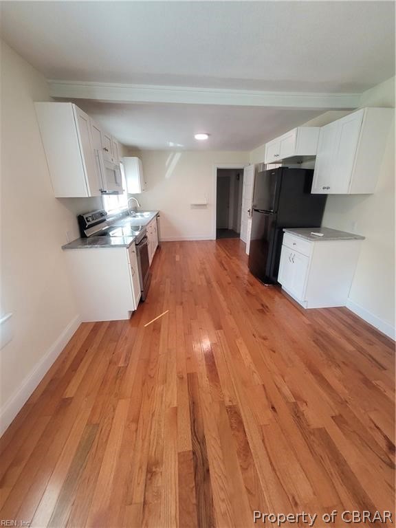 863 Urbanna Road Saluda, VA 23149 - Photo 6 of 24 Kitchen with black fridge, white cabinetry, light wood-type flooring, and stainless steel electric range oven