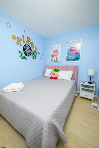 a bedroom with a bed and painting on the wall