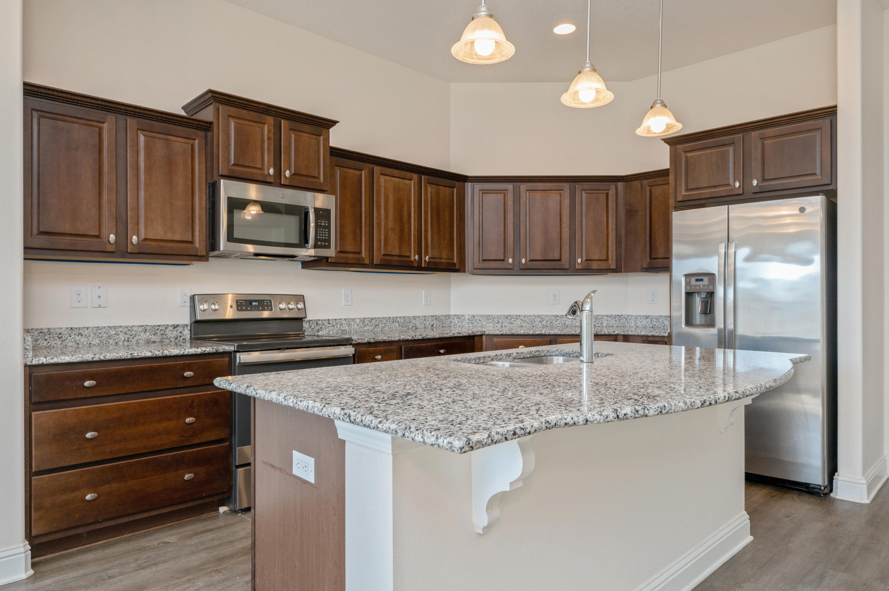 5662 North Brook Drive Crestview, FL 32539 - Photo 5 of 25 a kitchen with granite countertop a refrigerator stove and microwave