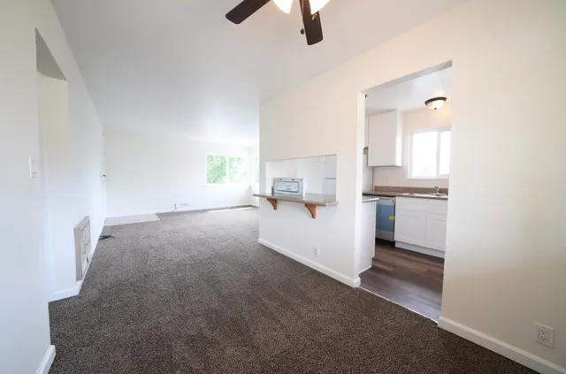 a kitchen with granite countertop white cabinets and white appliances
