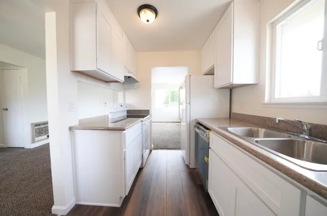 a kitchen with a sink cabinets and a window