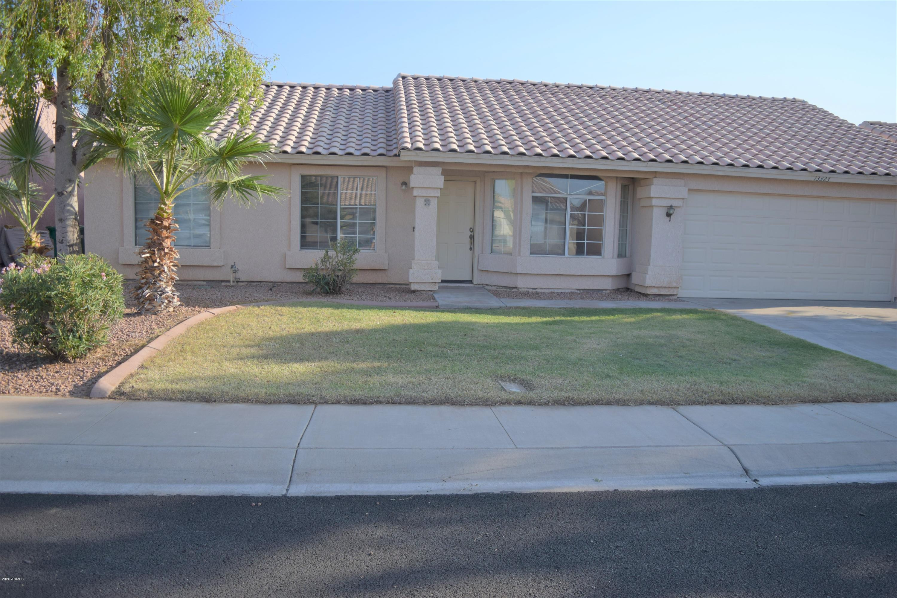 a view of a house with a patio and a yard