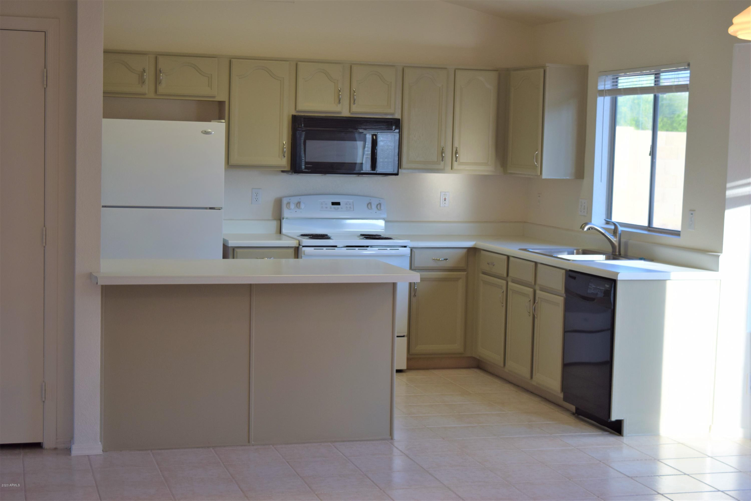 13323 East Butler Street Chandler, AZ 85225 - Photo 10 of 22 a kitchen with a sink a microwave a refrigerator and cabinets