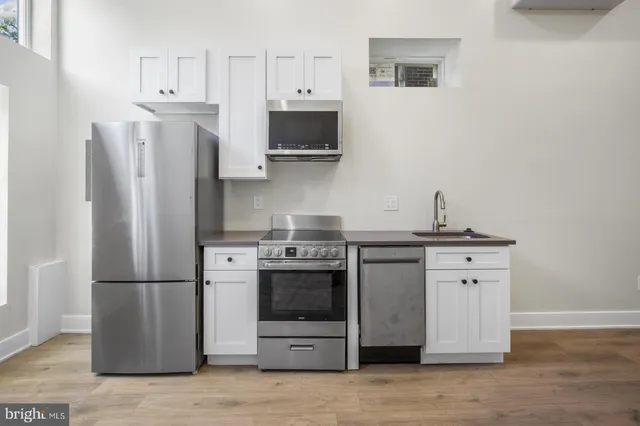 a kitchen with stainless steel appliances a stove refrigerator and cabinets