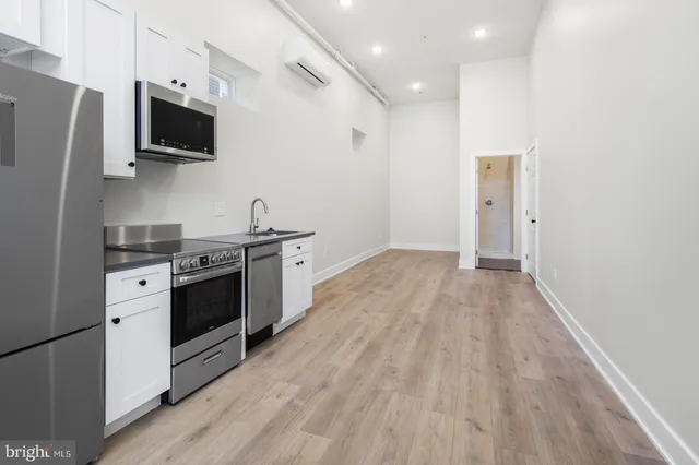 a kitchen with stainless steel appliances a stove top oven a sink and a refrigerator