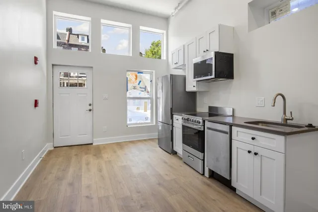 a kitchen with stainless steel appliances a stove microwave and sink