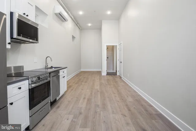 a kitchen with granite countertop a stove top oven and sink
