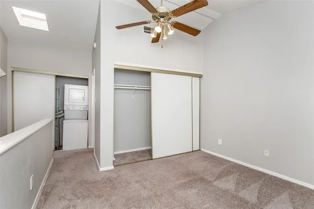 an empty room with closet and a chandelier fan