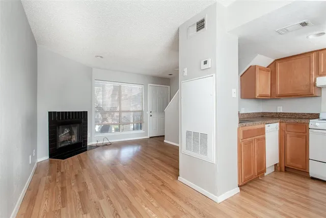 a view of a kitchen with wooden floor and a fireplace