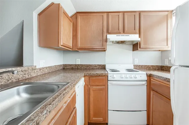 a kitchen with stainless steel appliances granite countertop a sink stove and cabinets