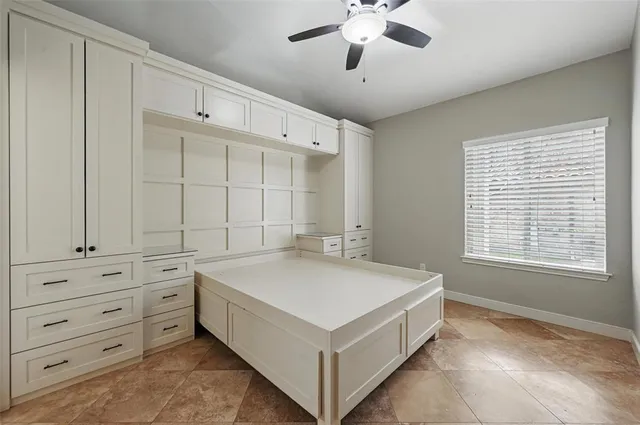 a spacious bedroom with a bed and a chandelier