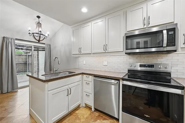 a kitchen with cabinets stainless steel appliances and wooden floor