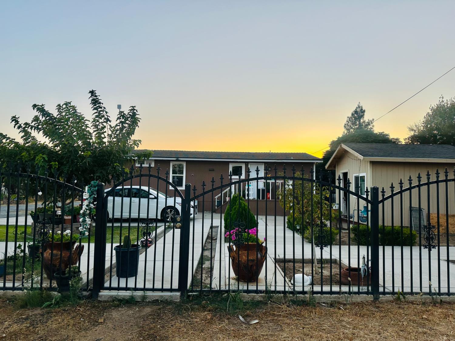 22788 Maple Street Chowchilla, CA 93610 - Photo 1 of 20 a view of a brick house with large windows and a small yard