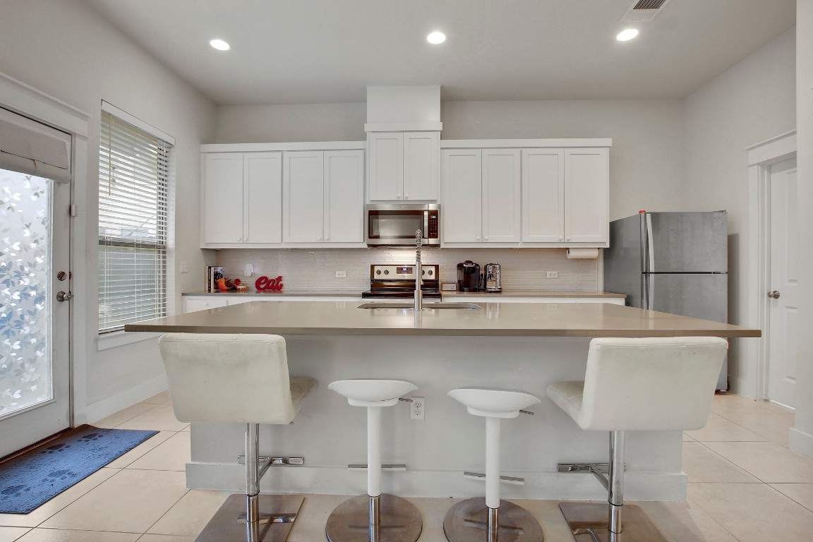 13001 Hymeadow Drive, Unit 39 Austin, TX 78729 - Photo 12 of 39 a kitchen with stainless steel appliances granite countertop a white table chairs and a refrigerator