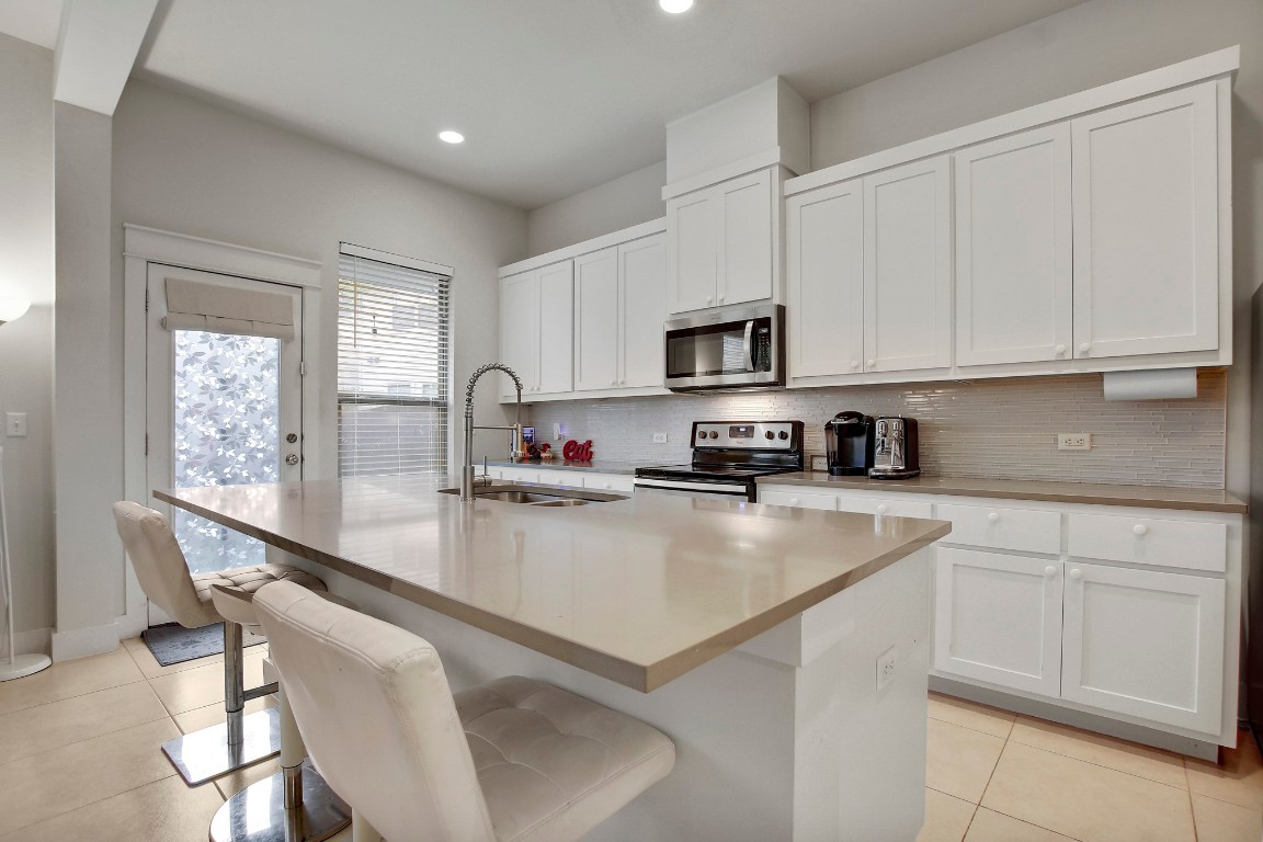 13001 Hymeadow Drive, Unit 39 Austin, TX 78729 - Photo 13 of 39 a kitchen with kitchen island granite countertop a sink counter top space appliances and cabinets