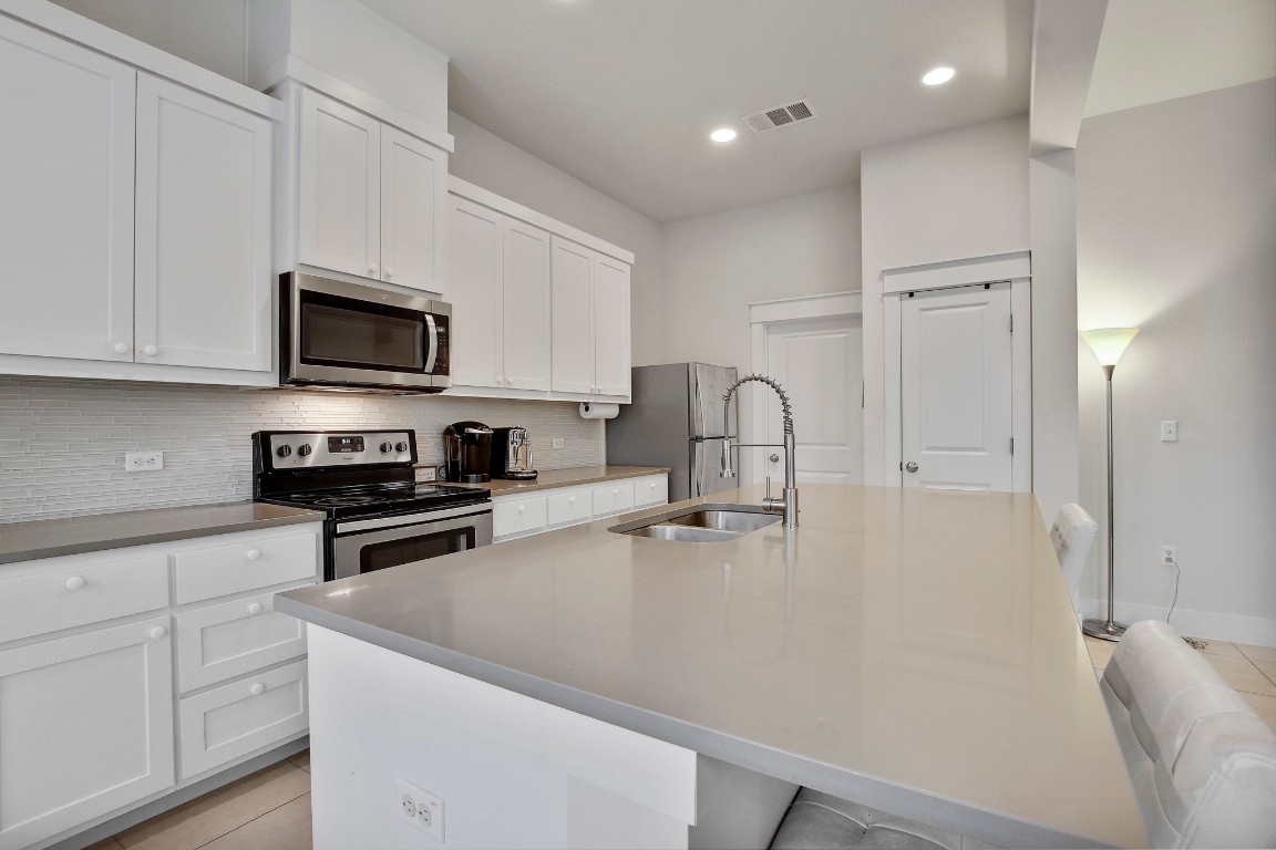 13001 Hymeadow Drive, Unit 39 Austin, TX 78729 - Photo 16 of 39 a kitchen with stainless steel appliances a stove microwave and sink