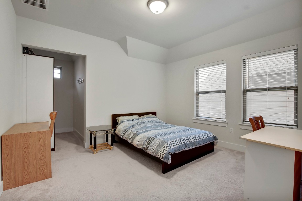 13001 Hymeadow Drive, Unit 39 Austin, TX 78729 - Photo 28 of 39 a spacious bedroom with a bed a table and windows
