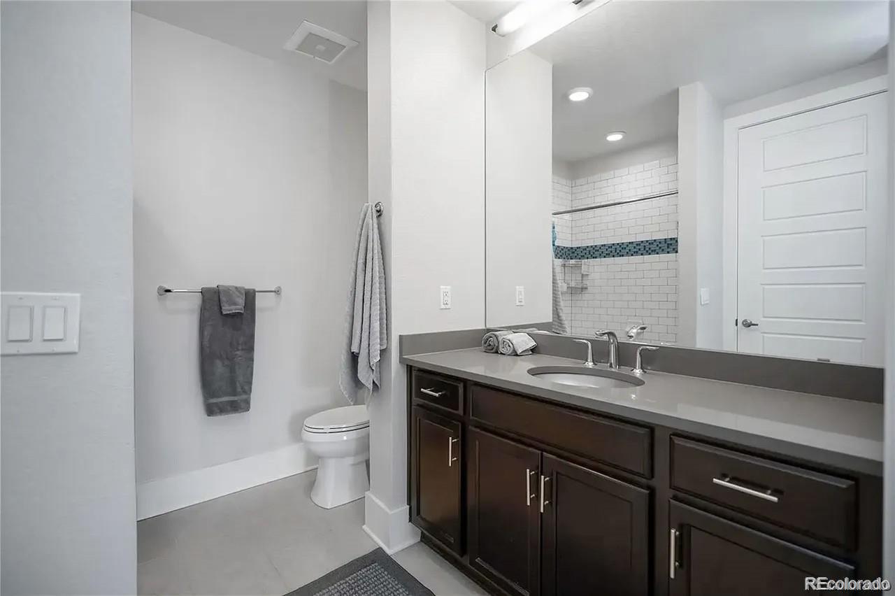 708 13th Street, Unit 250 Golden, CO 80401 - Photo 16 of 27 a bathroom with a granite countertop sink a toilet and mirror