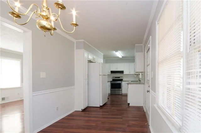 a view of a kitchen from the hallway with a window
