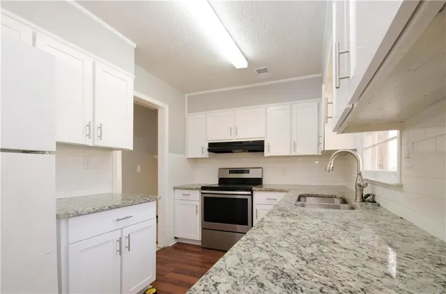 a kitchen with stainless steel appliances granite countertop a stove a sink and a granite counter tops