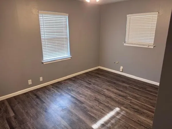 a view of a room with wooden floor and windows