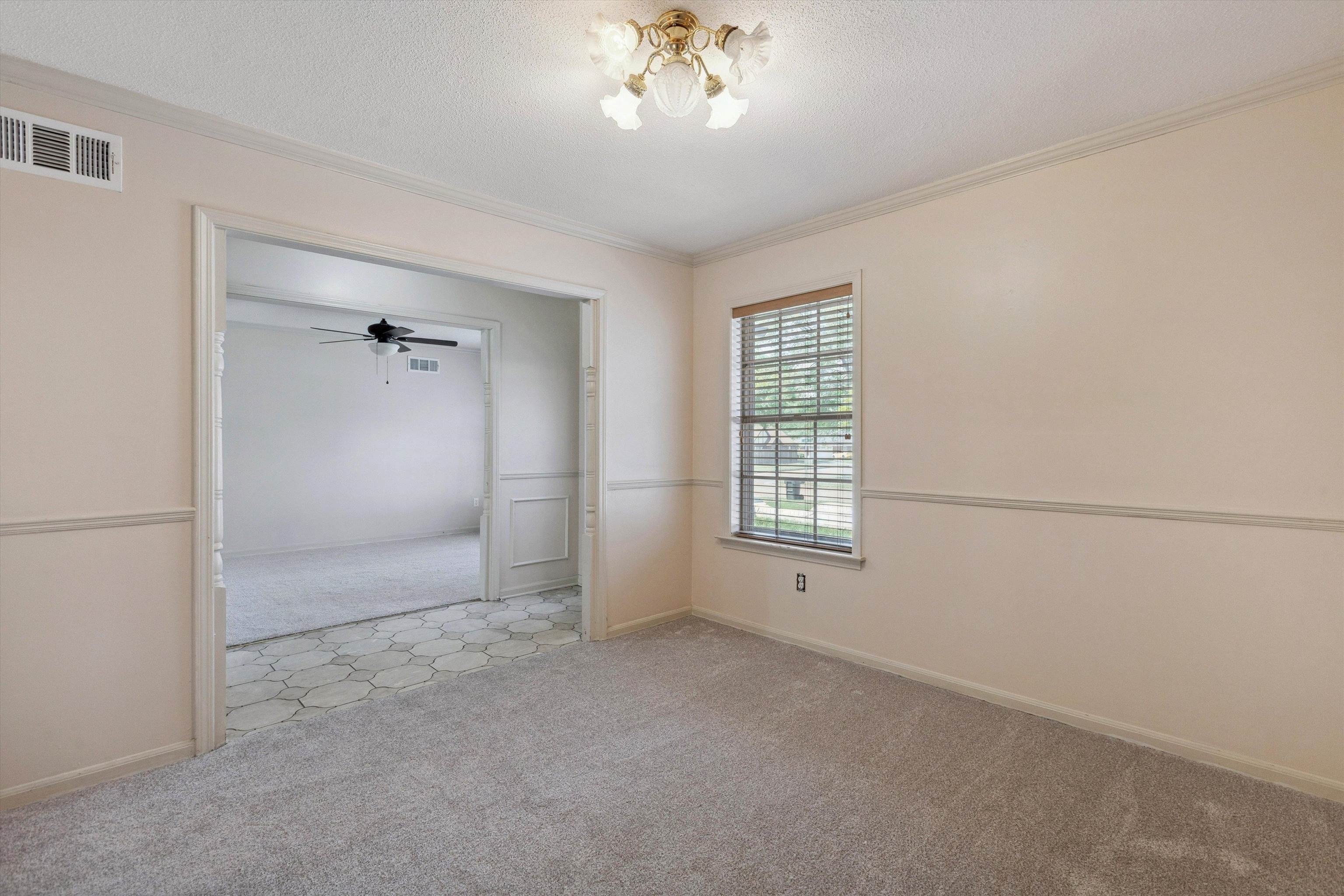 5747 Bartlett Woods Drive Bartlett, TN 38134 - Photo 11 of 28 Unfurnished room featuring visible vents, baseboards, a chandelier, crown molding, and light carpet