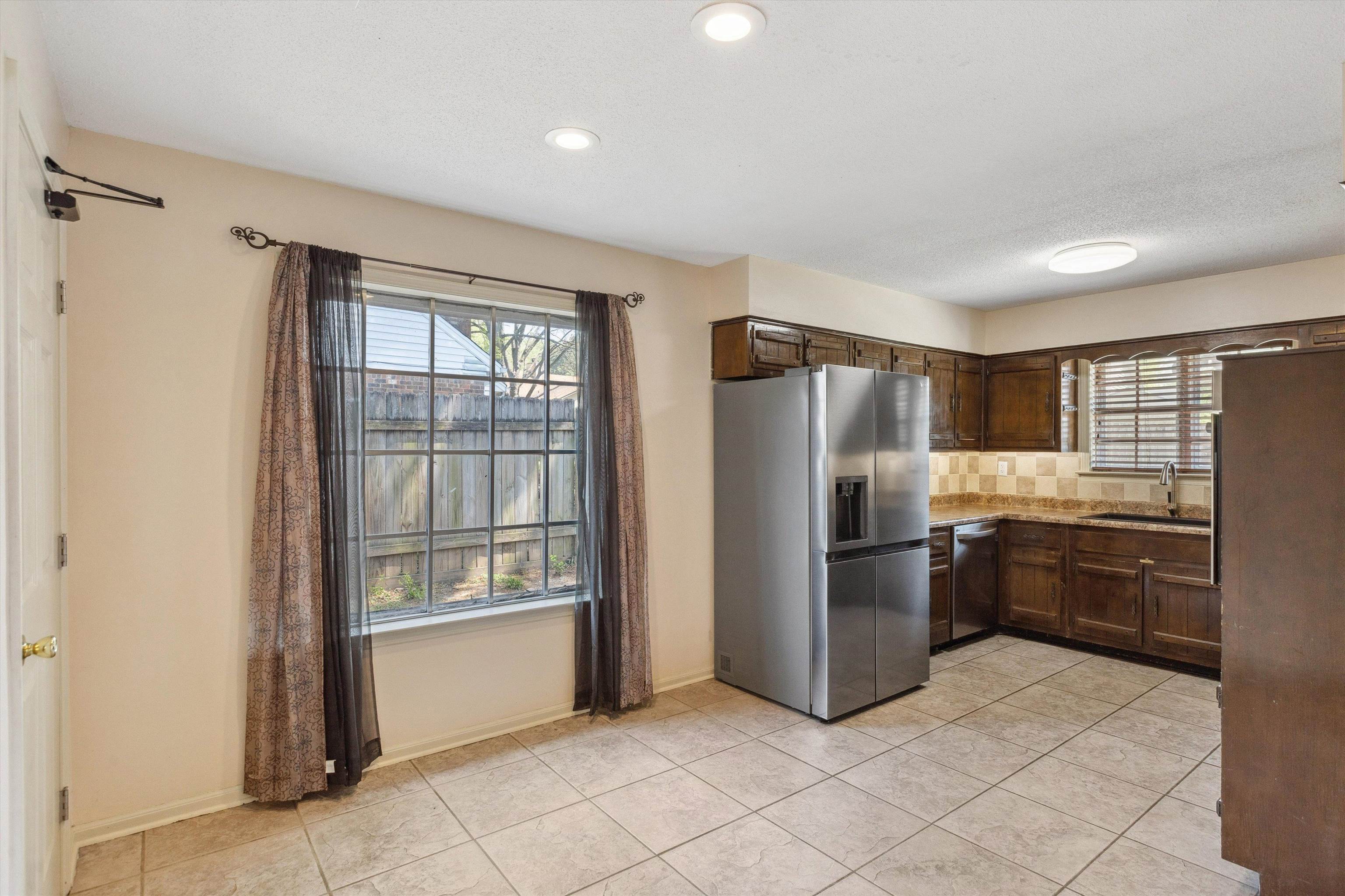 5747 Bartlett Woods Drive Bartlett, TN 38134 - Photo 14 of 28 Kitchen featuring tasteful backsplash, light tile patterned floors, a sink, appliances with stainless steel finishes, and dark brown cabinets