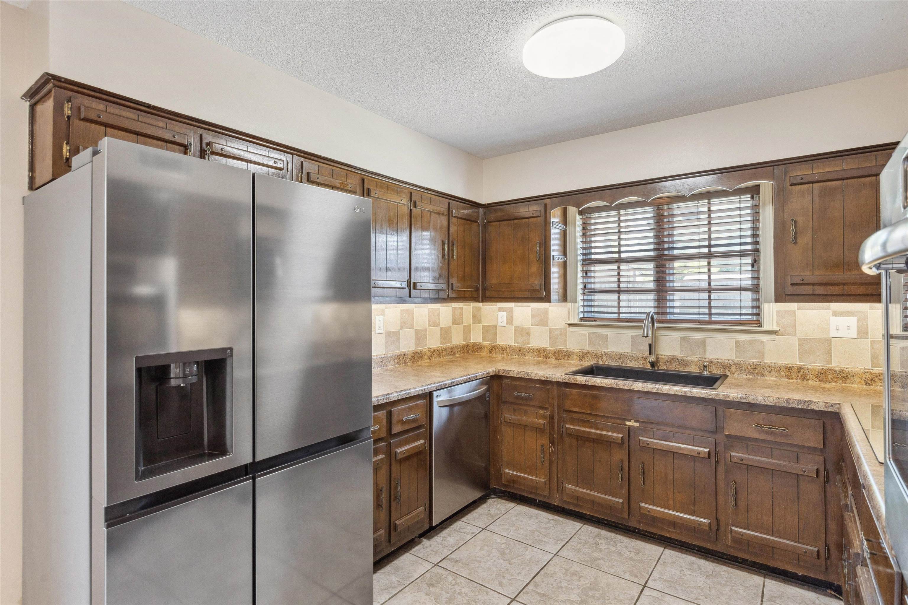 5747 Bartlett Woods Drive Bartlett, TN 38134 - Photo 15 of 28 Kitchen with a textured ceiling, light countertops, a sink, stainless steel appliances, and backsplash