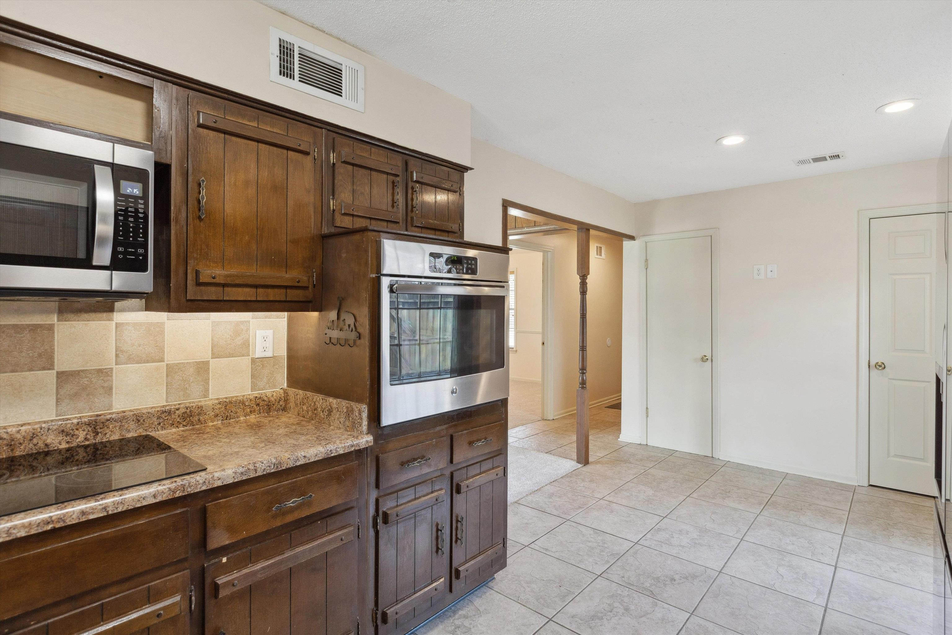 5747 Bartlett Woods Drive Bartlett, TN 38134 - Photo 16 of 28 Kitchen with appliances with stainless steel finishes, decorative backsplash, dark brown cabinets, and visible vents
