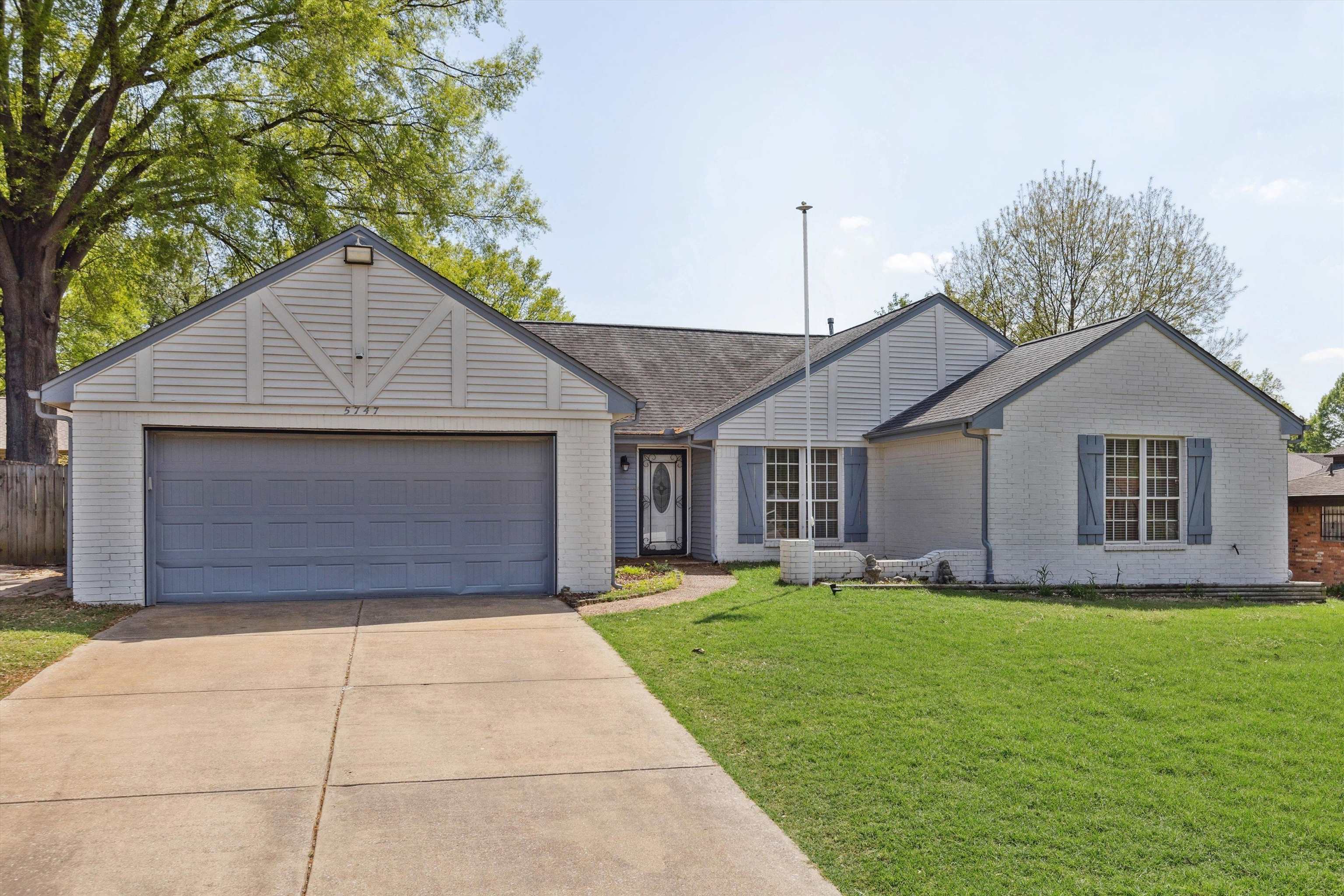 5747 Bartlett Woods Drive Bartlett, TN 38134 - Photo 3 of 28 Ranch-style home with an attached garage, concrete driveway, a front lawn, and brick siding