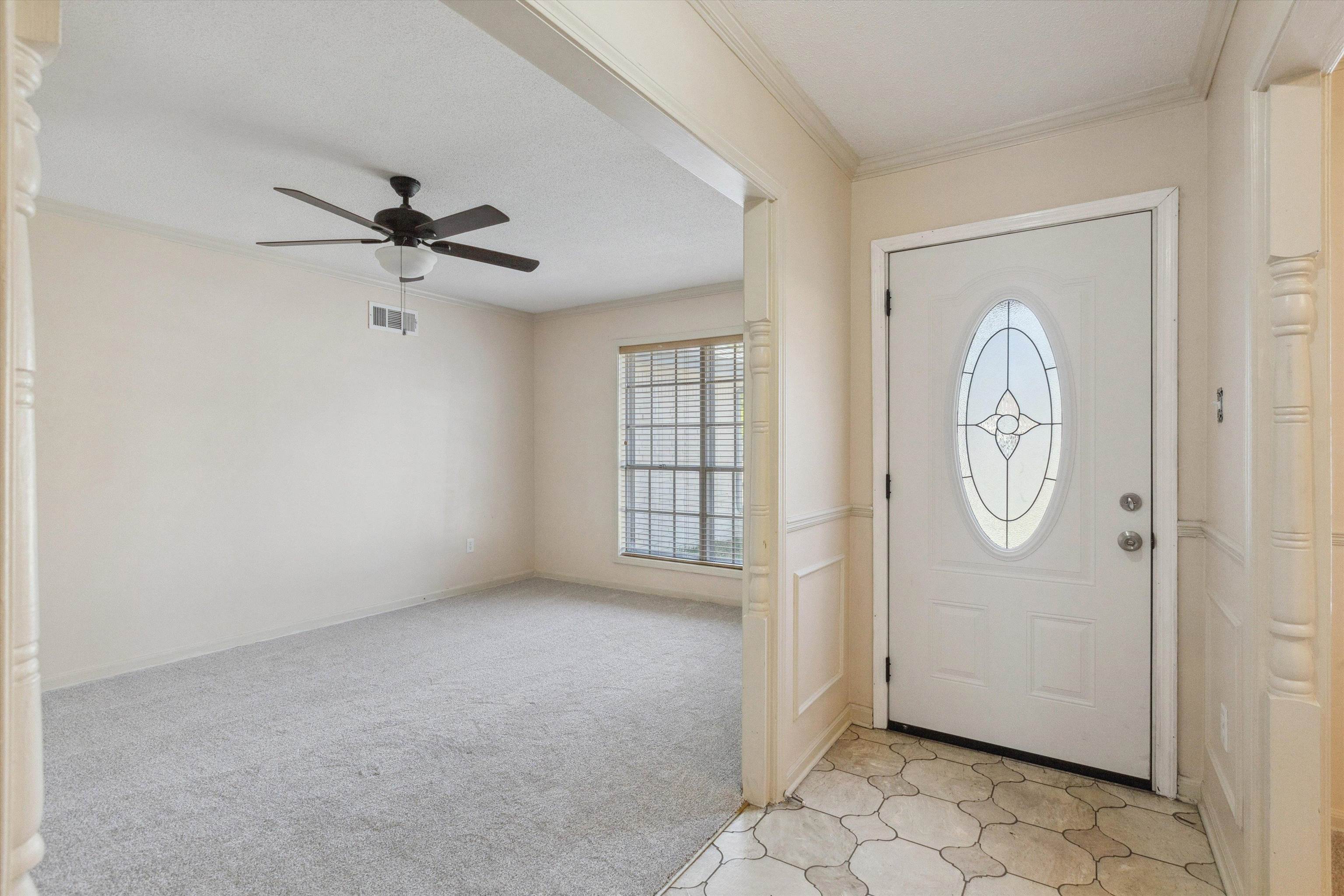 5747 Bartlett Woods Drive Bartlett, TN 38134 - Photo 7 of 28 Foyer entrance with ornamental molding, visible vents, ceiling fan, and light carpet