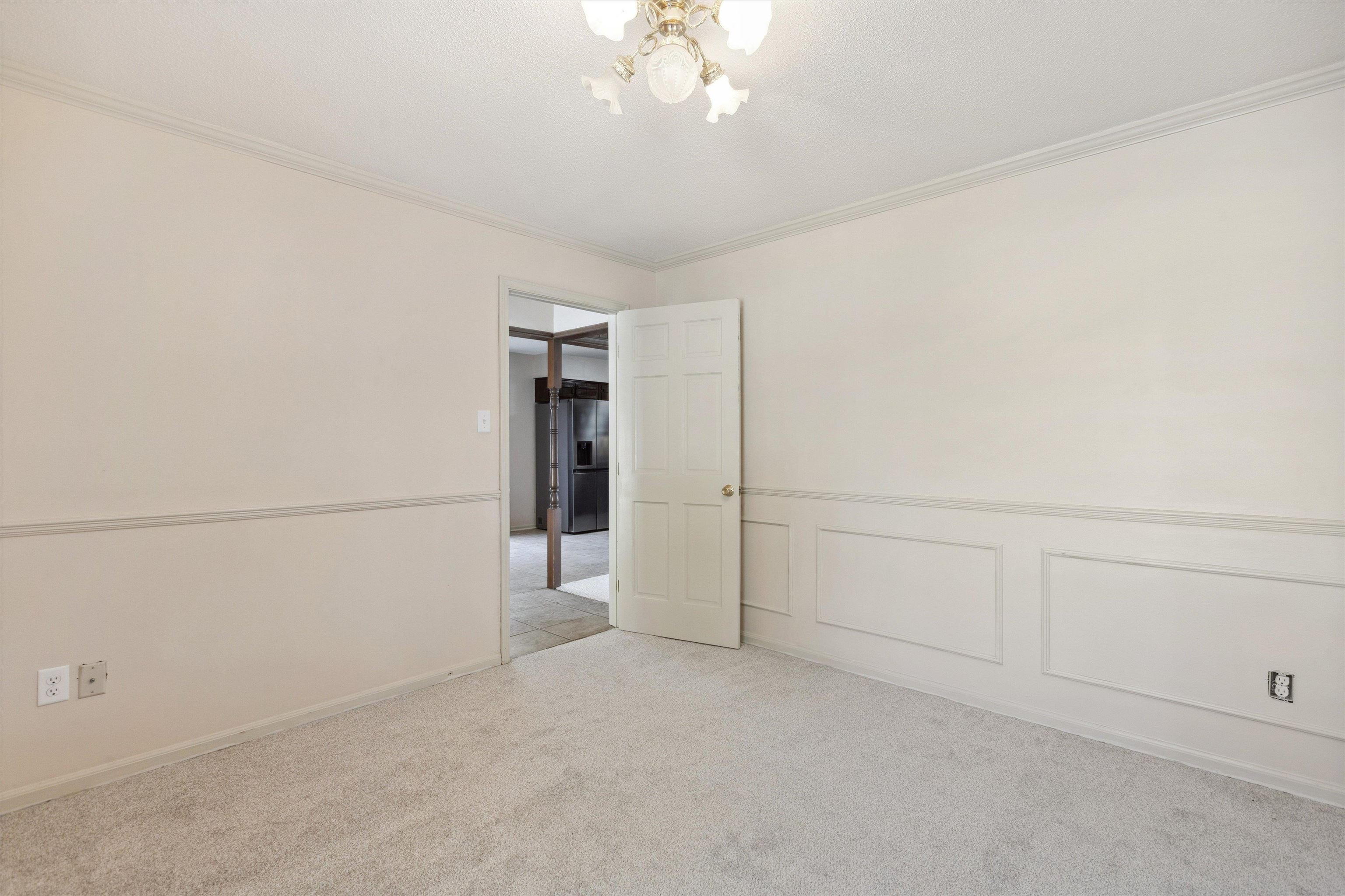 5747 Bartlett Woods Drive Bartlett, TN 38134 - Photo 10 of 28 Unfurnished room featuring a chandelier, wainscoting, light carpet, and crown molding