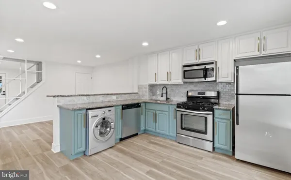 a kitchen with stainless steel appliances granite countertop a stove a sink and a refrigerator