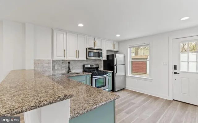 a kitchen with a stove a sink and a microwave