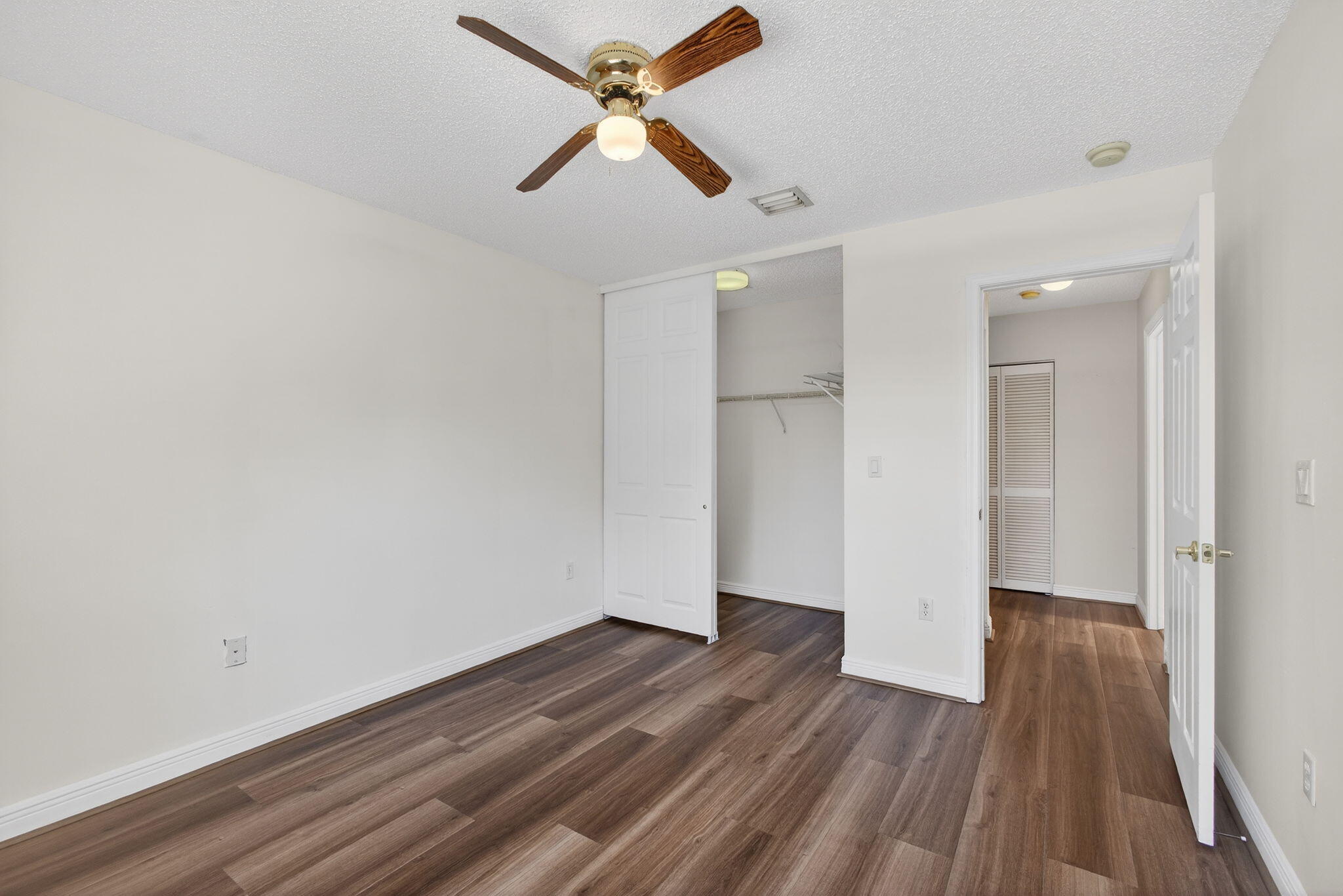 2008 Reston Circle Royal Palm Beach, FL 33411 - Photo 46 of 57 an empty room with wooden floor ceiling fan and windows