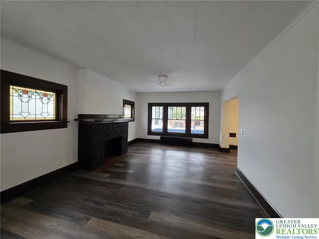 a view of a livingroom with wooden floor and stairs