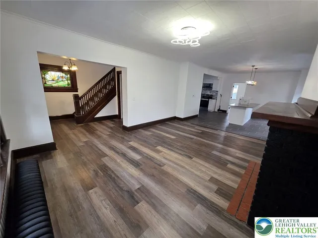 a view of a livingroom with wooden floor and stairs