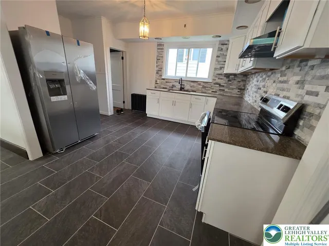 a kitchen with stainless steel appliances a stove a sink a microwave and a refrigerator