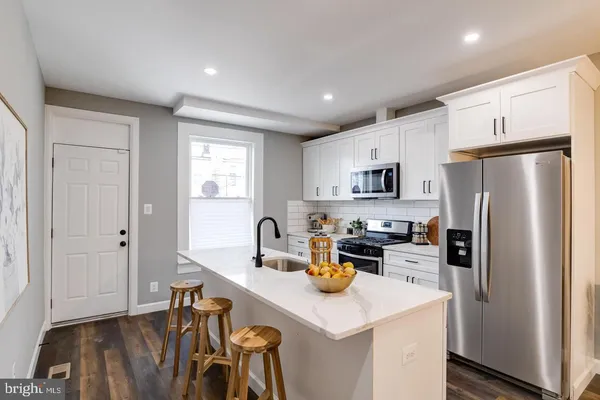 a kitchen with refrigerator and white cabinets