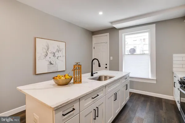 a kitchen with stainless steel appliances a sink and a wooden floor