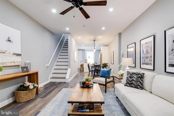 a living room with furniture and a wooden floor