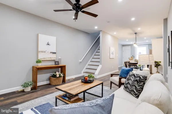 a living room with furniture and a wooden floor
